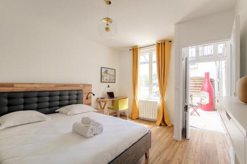 a bedroom with a large bed with towels on it at Maison avec terrasse proche Lyon in Rillieux