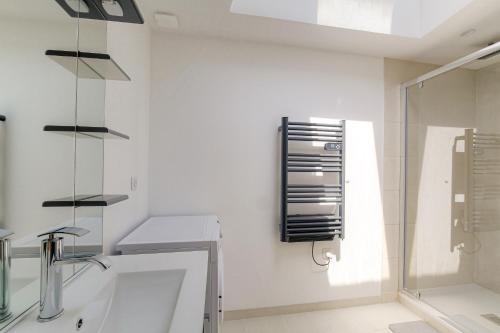 a white bathroom with a sink and a shower at Maison avec terrasse proche Lyon in Rillieux