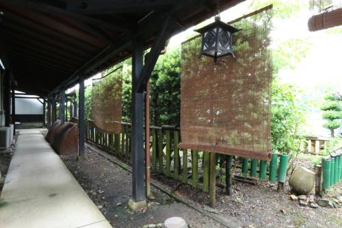 a porch with a bench next to a fence at 旅館早水荘 in Yunoo