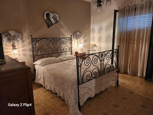 a bedroom with a bed with a wrought iron bed frame at B&b I DUE ANGELI in Quadrelle