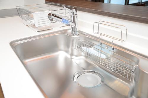 a kitchen sink with a dish drying rack next to it at Shinjuku NY House 301 in Tokyo