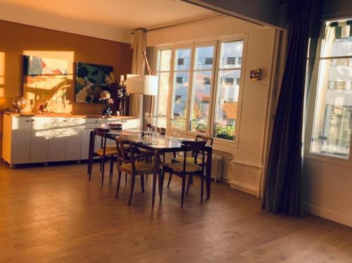 une cuisine et une salle à manger avec une table et des chaises dans l'établissement Magnifique appartement proche tour Eiffel, à Paris