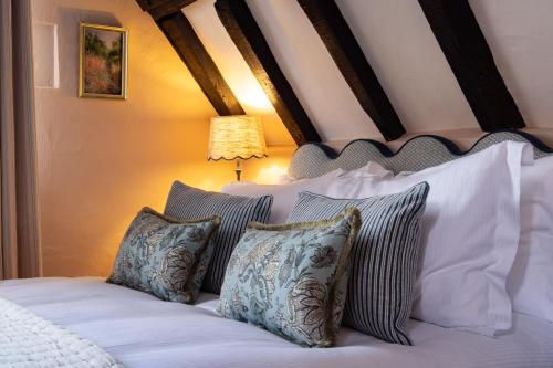 a bedroom with a bed with white sheets and pillows at The White Hart - A Heartwood Inn in Lewes