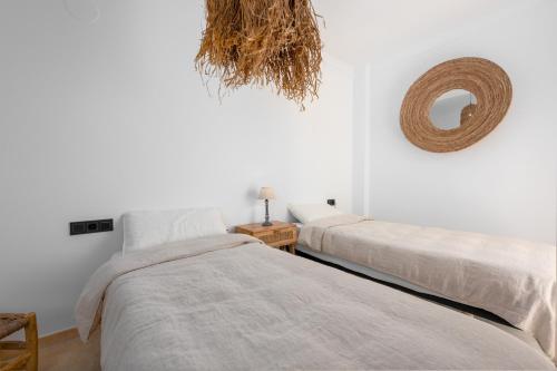 two beds in a white room with a mirror at San Roque 5001 Golf&Relax in San Roque