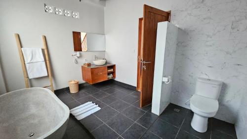a bathroom with a toilet and a sink at Bhalance Retreat in Padangbai
