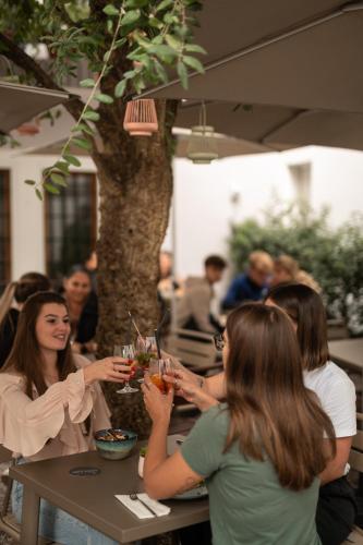 a group of people sitting at a table with drinks at Kuntino Suites in Merano