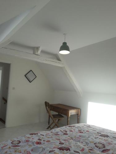 une chambre avec un lit et une table en bois dans l'établissement Gite de l'allée Arras Dainville, à Dainville