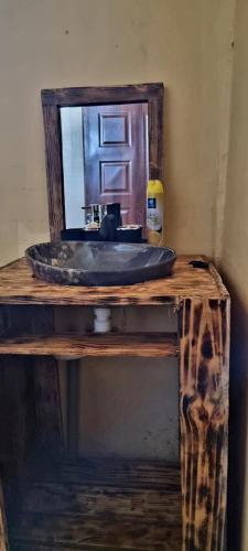 a bathroom sink with a mirror on a wooden table at Amanya 2 Bedroom Self Catering Tent in Amboseli