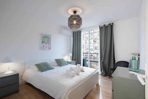 une chambre avec un lit blanc et une grande fenêtre dans l'établissement Appartement Marseille VIEUX PORT, à Marseille