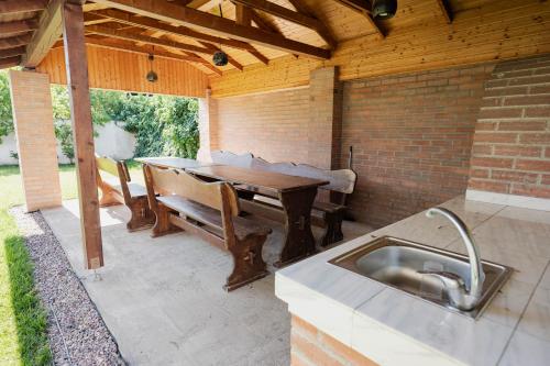 a patio with a table and a bench and a sink at Casa Korman in Giarmata