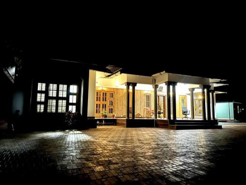 a lit up building with a brick courtyard at night at Entire Private Luxury Resort in Wayanad - Cinnamon Villa Wayanad in Panamaram