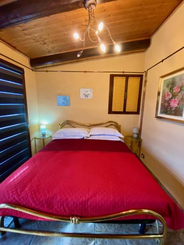 a bed in a room with a red blanket at Residence delle Rose in Barolo