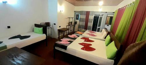 a room with two beds and a mirror at Sinharaja Vini Villa in Deniyaya
