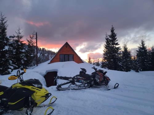two motorcycles parked in the snow in front of a cabin at არწივის ბუდე eagle's nest in Goderdzi