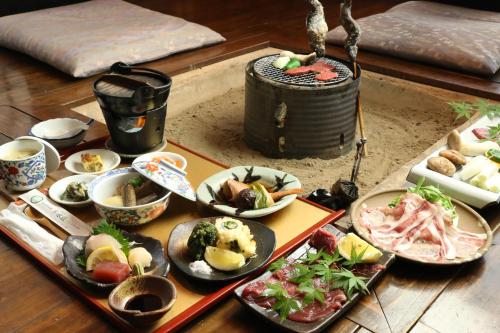 a table filled with different types of food on plates at 旅館早水荘 in Yunoo