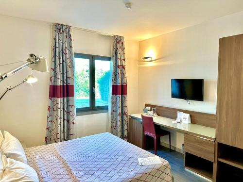 a hotel room with a bed and a desk at Hotel Del Parco in Vigevano