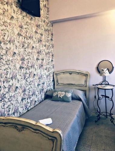 a bedroom with a bed and a wall at La Dimora Porto economy in Gioia Tauro