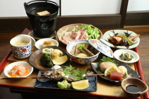 a table with plates of food and bowls of food at 旅館早水荘 in Yunoo