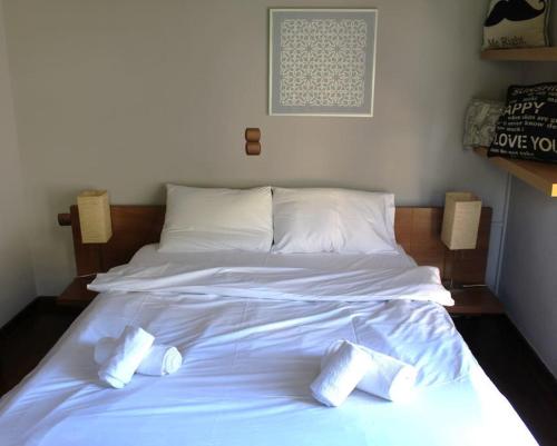 a large white bed with three pillows on it at Elis studio luxury apartment in Ierápetra