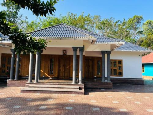 a house with columns and a roof at Entire Private Luxury Resort in Wayanad - Cinnamon Villa Wayanad in Panamaram