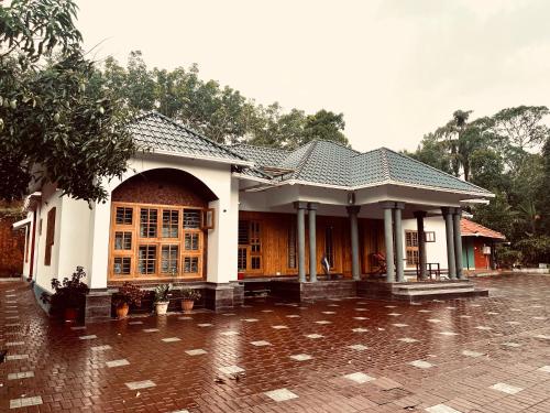 a house in the rain on a brick courtyard at Entire Private Luxury Resort in Wayanad - Cinnamon Villa Wayanad in Panamaram