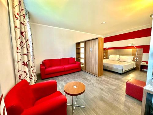 a hotel room with a red couch and a bed at Hotel Del Parco in Vigevano