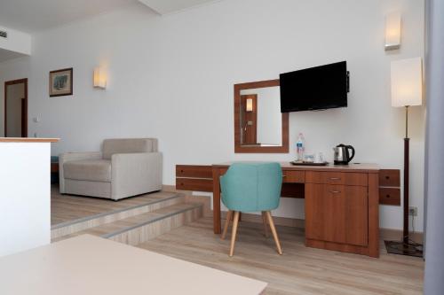 a room with a desk and a chair and a television at Alua Helios Bay - All Inclusive in Obzor