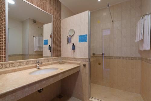 a bathroom with a sink and a shower at Alua Helios Bay - All Inclusive in Obzor