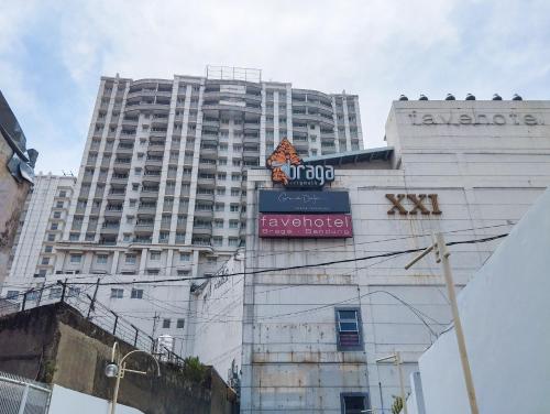 a tall white building with a sign in front of it at Tranquil Designed 2BR at Braga City Walk Apartment By Travelio in Bandung