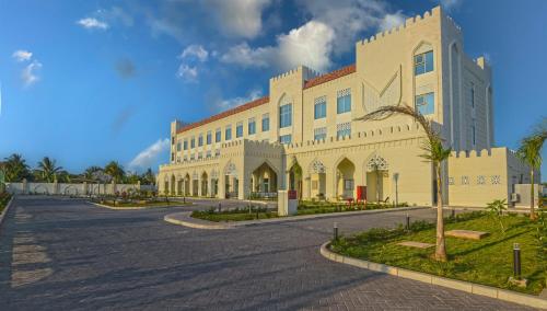 a large white building with a street in front of it at Golden Tulip Zanzibar Airport Hotel & Spa in Zanzibar City