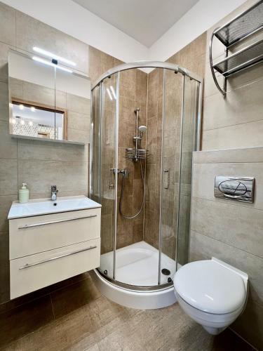 a bathroom with a shower and a toilet and a sink at Móló Resort 25 by HelloBalatonlelle in Balatonlelle
