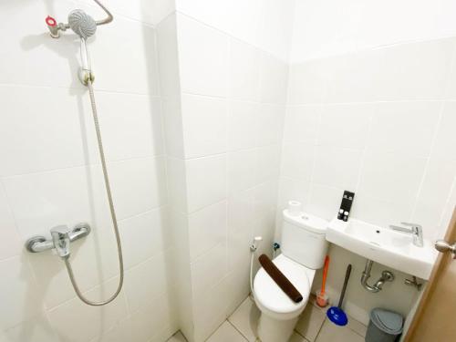a bathroom with a shower with a toilet and a sink at Homey Studio Cordova Edupartment Semarang Apartment By Travelio in Semarang