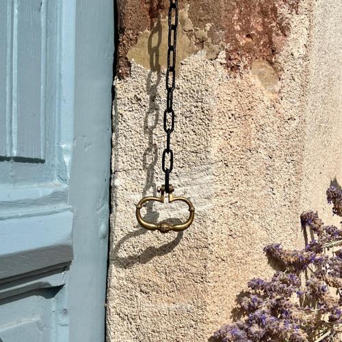 a chain with a heart on the side of a building at Le manoir de Jasmine in Chabrignac