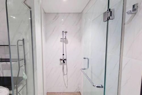 una ducha con puerta de cristal en un baño en 1BR Premium Branz BSD Apartment by OWARI, en Samporo