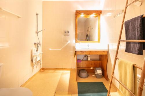 une salle de bain avec un lavabo et un miroir dans l'établissement Hermine - apt 6p vue montagne, à Chamrousse