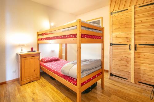 une chambre avec deux lits superposés et une commode dans l'établissement Hermine - apt 6p vue montagne, à Chamrousse
