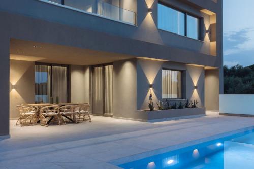 a house with a patio with a table and chairs at Villa Frantzeska - Elegant Villa close to Tsilivi, by ZanteWize in Tsilivi
