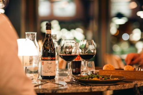 a bottle of wine sitting on a table with wine glasses at Hotell Lappland in Lycksele