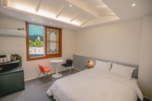 a bedroom with a white bed and a window at HotelArrive Jeonju Sihwayeonpung in Jeonju