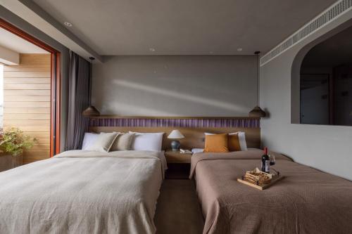 a bedroom with two beds and a table with a bottle of wine at QiPan Holiday hotel Lugu Lake in Ninglang