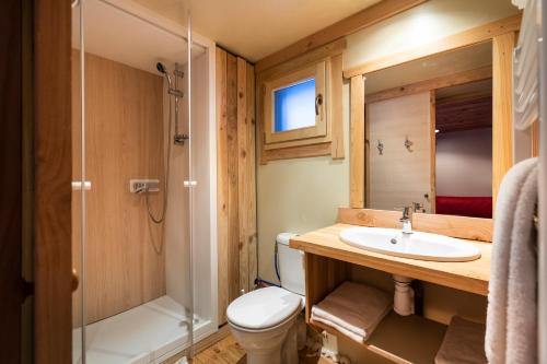 une salle de bain avec toilettes, lavabo et douche dans l'établissement Huttopia Bourg St Maurice, à Bourg-Saint-Maurice