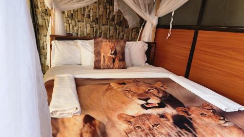 een slaapkamer met een bed met twee leeuwen erop bij Little Amanya Camp in Amboseli