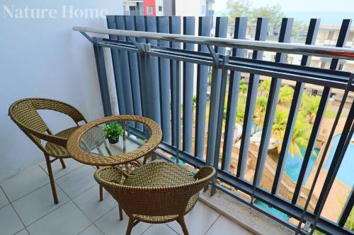 two chairs and a table on a balcony at Nature Home - Swiss Garden Resort Residences in Kuantan