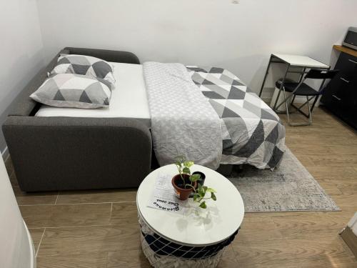 Cette chambre dispose d'un lit avec une table et d'une table. dans l'établissement Studio Cosy au Cœur de Paris 11e, à Paris