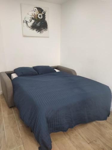 - un lit avec une couette bleue dans une chambre dans l'établissement Studio Cosy au Cœur de Paris 11e, à Paris