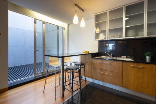a kitchen with a table and some stools in it at Casa Sao Francisco in Montanha de Santa Luzia