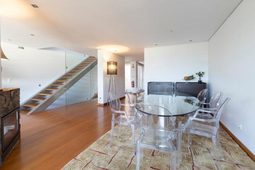 a dining room with a glass table and chairs at Casa Sao Francisco in Montanha de Santa Luzia