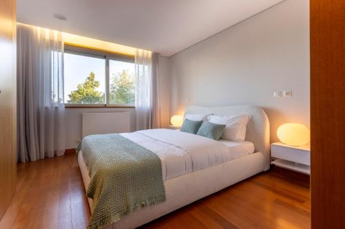 a white bedroom with a bed and a window at Casa Sao Francisco in Montanha de Santa Luzia