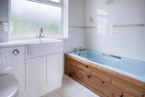 une salle de bain avec une baignoire, un lavabo et des toilettes dans l'établissement Longview - 4 Bedroom Holiday Home - Pembroke Dock, à Pembroke Dock