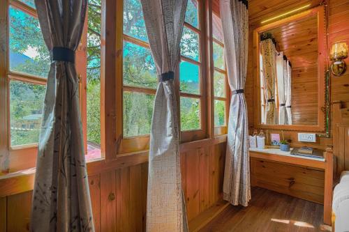 a bedroom with windows in a wooden cabin at Pax Hotel Rock Villa Swimming Pool Available Dalhousie in Dalhousie